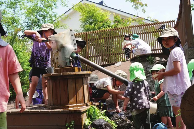 園庭のガチャポンプで水遊びをする子どもたち