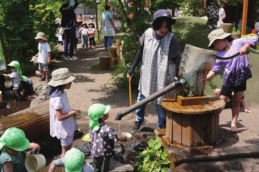 園庭のガチャポンプで水遊びをする子どもたち